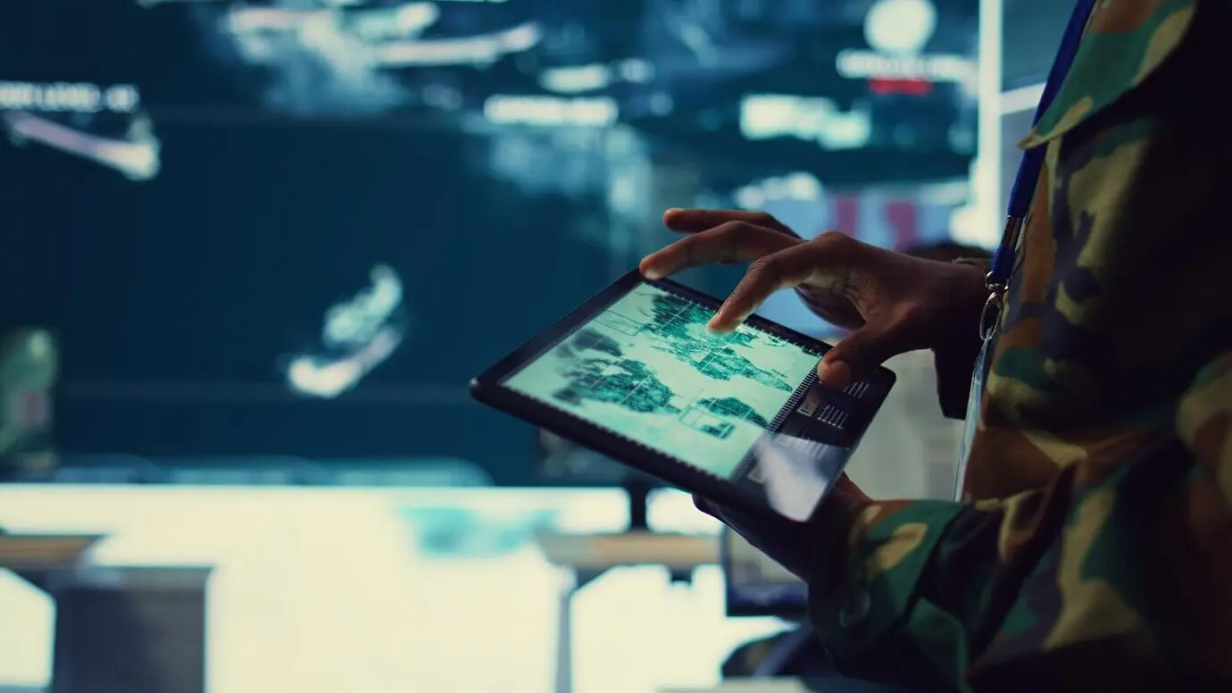 Un soldado del ejército revisa objetivos en un mapa mundial satelital para garantizar la protección global.